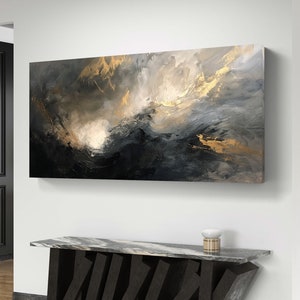 Op de afbeelding: Abstract schilderij met een donkerblauwe en grijze achtergrond met gouden accenten. Het schilderij hangt aan een witte muur boven een zwarte marmeren tafel.