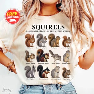 May include: An ivory t-shirt featuring a graphic print titled SQUIRRELS ILLUSTRATED SPECIES OF THE SCIURID WORLD. The design displays twelve detailed illustrations of various squirrel species with their names printed in black text below each.