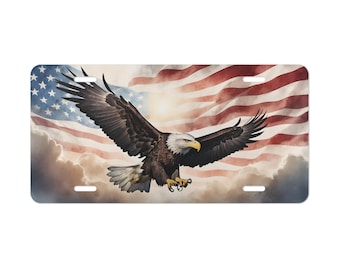 May include: Rectangular license plate featuring a majestic bald eagle in flight against a backdrop of the American flag. The eagle has brown and white feathers, a yellow beak, and outstretched wings. The flag displays red and white stripes and a field of blue with white stars.
