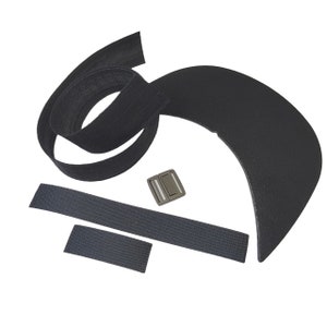Puede incluir: Un conjunto de piezas de sombrero de tela negra y una hebilla de plástico negra. Las piezas incluyen una visera curva, una tira larga de tela, una tira corta de tela y una pieza cuadrada de tela más pequeña.