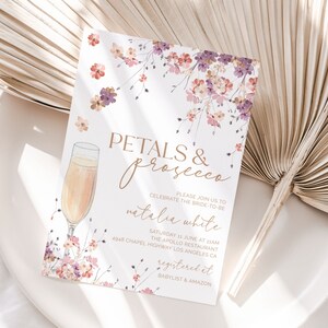 May include: A floral-themed bridal shower invitation with a glass of champagne and the text "Petals & Prosecco" in gold lettering. The invitation includes the bride-to-be's name, the date, time, and location of the event, as well as information about where to register for gifts.