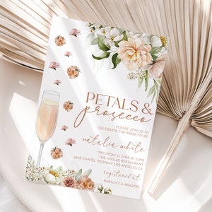 May include: A white invitation with a floral design and gold lettering. The invitation reads "Petals & Prosecco" and invites guests to celebrate the bride-to-be, Natalia White. The event will be held on Saturday, June 11th at 11am at The Apollo Restaurant, 4948 Chapel Highway, Los Angeles, CA. The invitation also includes the text "Registered at Babylist & Amazon."