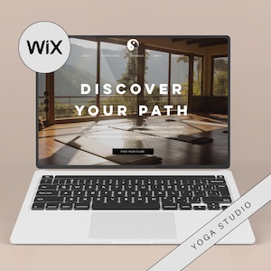 Puede incluir: Un ordenador portátil que muestra un sitio web para un estudio de yoga. El sitio web presenta una foto de un estudio de yoga con grandes ventanas y el texto "Discover Your Path". El portátil está sobre una superficie marrón claro con el texto "Yoga Studio" en una franja blanca.