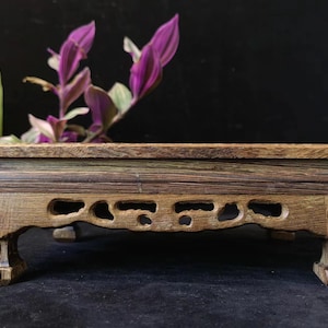 Op de afbeelding: Een witte keramische mok met een zwarte handgreep en de tekst "But First, Coffee" in een vetgedrukte, zwarte letter. De mok staat tegen een vage achtergrond, wat een gezellige setting suggereert.