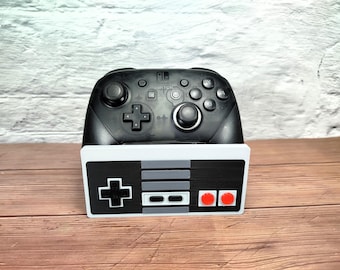 Controller holder based on Nintendo NES controller, compatible with PlayStation, Xbox, and Switch.
