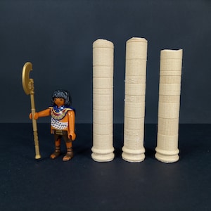 Peut inclure: Trois colonnes beiges avec un motif décoratif. Les colonnes sont en matériau texturé et ont un sommet arrondi.