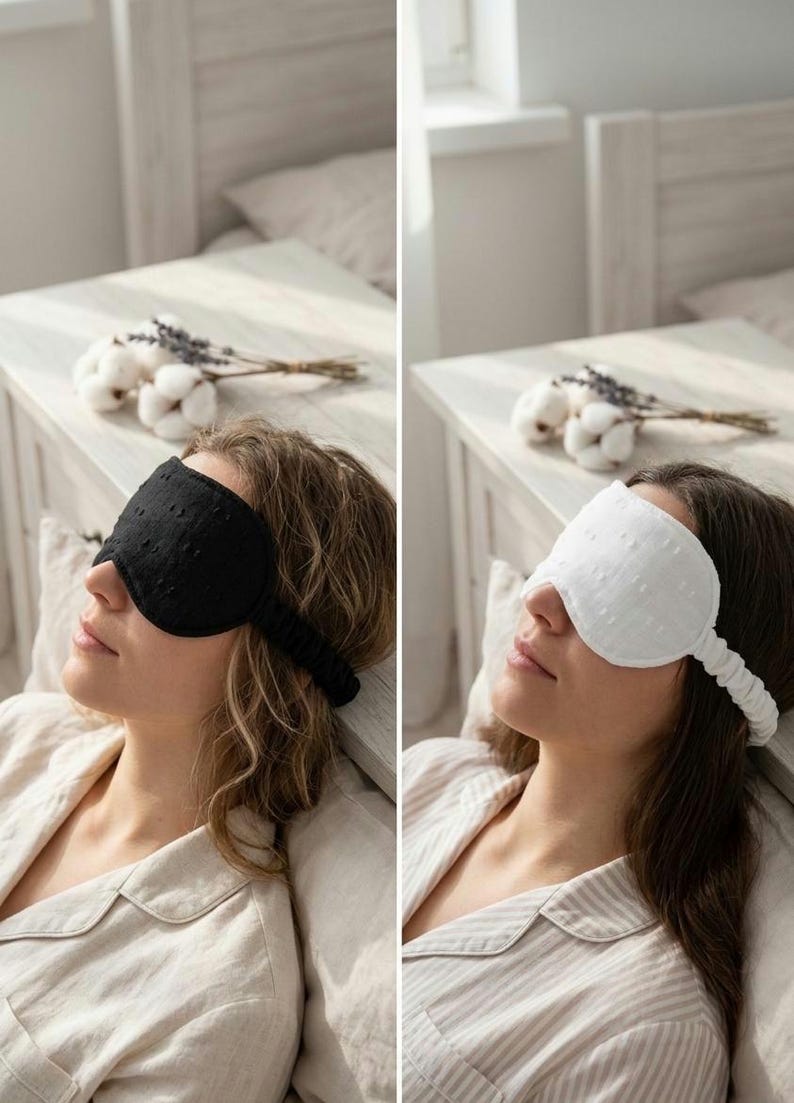 May include: Two eye masks, one black and one white, are shown in this image. Both masks have a textured, dotted pattern and a strap to secure them. The black mask is on the left, and the white mask is on the right. The masks are designed for sleep and relaxation.