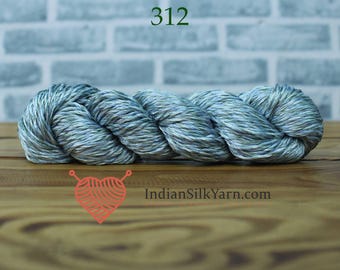 May include: A skein of yarn in shades of blue, green, and gray. The yarn is tightly twisted and appears soft. The number "312" is printed in green at the top. The website "IndianSilkYarn.com" is printed at the bottom.