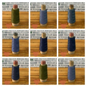 Peut inclure: Une grille de neuf bobines de fil dans diverses nuances de bleu et de vert olive, chacune enroulée sur un noyau en carton. Certaines bobines présentent du papier à motifs sur le dessus. Le texte IndianSilkYarn.com est visible sur chaque section.