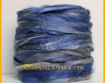 May include: A skein of blue and white silk yarn. The yarn is loosely wound and has a soft, fluffy texture. The skein is labeled "indiansilkyarn.com".