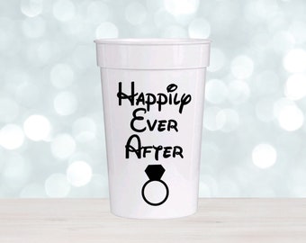 May include: White plastic cup with black text that reads "Happily Ever After" and a black ring with a diamond.
