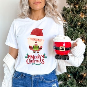 May include: White t-shirt with a cartoon Santa Claus holding a gift and the text "Merry Christmas".