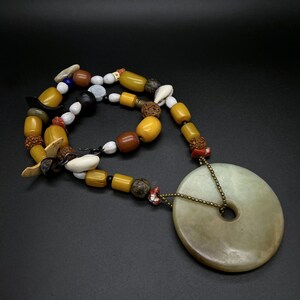 Vintage boho ketting met jade schijfjes, bakelieten schelp- en hoornkralen, etnische statement sieraden uit de jaren 70