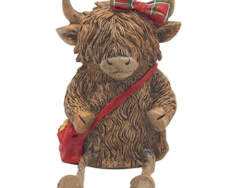 Adorno de vaca de las Tierras Altas con patas colgantes y lazo de tartán.
