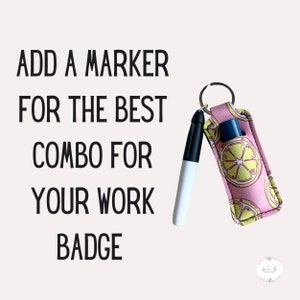 Peut inclure: Un porte-cl&eacute;s en tissu imprim&eacute; de citrons jaunes et roses avec un marqueur effa&ccedil;able &agrave; sec noir et blanc attach&eacute;. Le texte "ADD A MARKER FOR THE BEST COMBO FOR YOUR WORK BADGE" est &eacute;crit en noir sur fond blanc.