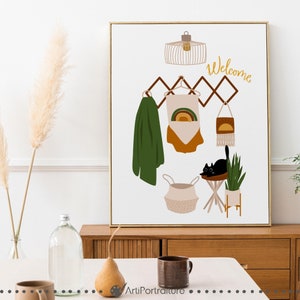 May include: A white canvas print with a brown wooden frame. The print features a black cat sitting on a stool, a green jacket hanging on a rack, a basket, a plant, and a light fixture. The text "Welcome" is written in yellow on the print.