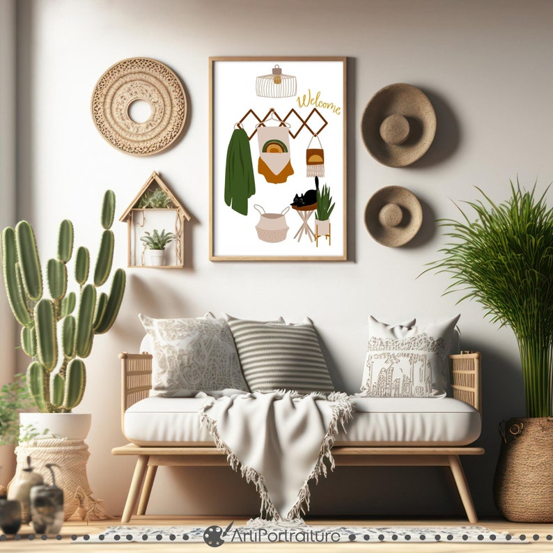 May include: A framed print with a white background and a black cat sitting on a stool. The print also features a green scarf, a rainbow-colored shirt, a white tank top, and a welcome sign. The print is hanging on a white wall with a cactus plant in a pot and a wooden bench with pillows and a blanket.