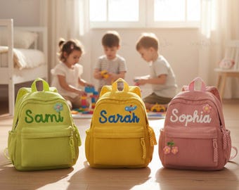 May include: Three corduroy backpacks in green, yellow, and pink, each with a name embroidered on the front: Sami, Sarah, and Sophia. The backpacks have a front pocket, side pockets, and a top handle. Floral and airplane embellishments.