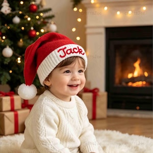 Puede incluir: Un gorro de Papá Noel de punto rojo y blanco con un pompón blanco en la punta y el nombre Jack bordado en cursiva roja sobre el borde acanalado blanco. El gorro está hecho de un material de punto suave y texturizado.