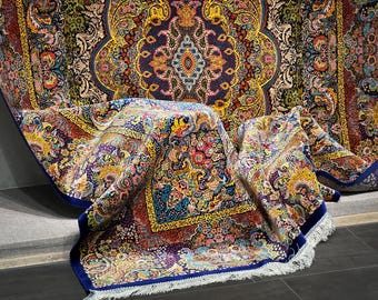 Könnte beinhalten: Aufwendiger Teppich im persischen Stil mit komplexen floralen und geometrischen Mustern in Blau-, Rot-, Gelb- und Grüntönen. Der Teppich hat einen dunkelblauen Rand und einen weißen Fransen. Das Design ist detailliert und zeigt traditionelle Handwerkskunst.