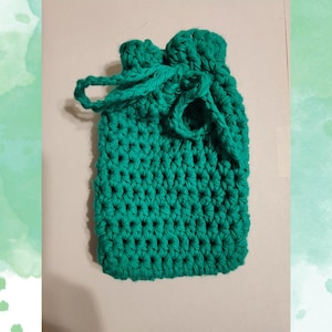 May include: A teal green crocheted drawstring bag with a knotted handle.