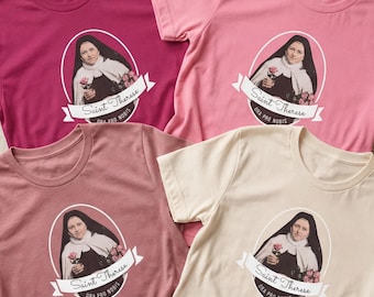 Op de afbeelding: Vier T-shirts met korte mouwen in de kleuren donkerroze, lichtroze, mauve en crème. Elk shirt heeft een centrale afbeelding van de Heilige Theresia in een zwart habijt met rozen, in een ovaal kader met de tekst Saint Therese Ora Pro Nobis.