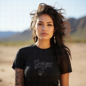 May include: A woman wearing a black t-shirt with the text "Your design here" printed on it. She has long dark hair and is wearing earrings.