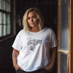 May include: A white t-shirt with a black and white graphic of an animal with the text "Your design here" on the front.