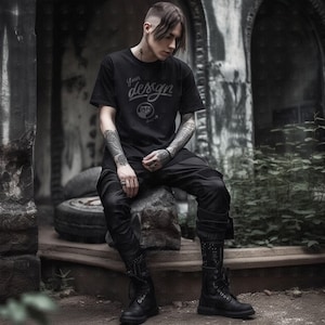Könnte beinhalten: Eine Person trägt ein schwarzes T-Shirt mit dem Text "Your design" und einer Grafik eines Yin-Yang-Symbols. Sie trägt auch eine schwarze Hose und schwarze Stiefel.
