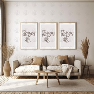 May include: Three framed prints with the text "Your design here" in a living room setting with a white couch, a wooden coffee table, and a vase of dried pampas grass.