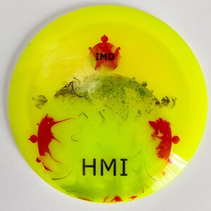 May include: Yellow disc with red and green splatter paint. The disc has the text "IMD" and "HMI" printed on it.