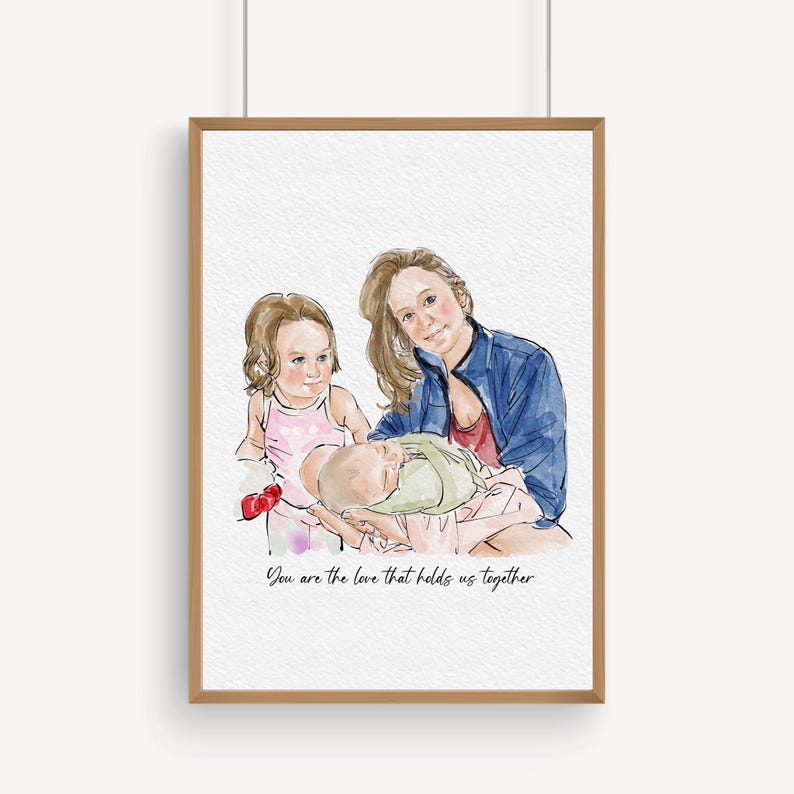 K&ouml;nnte beinhalten: Aquarellportr&auml;t in einem Holzrahmen. Das Kunstwerk zeigt eine Mutter mit zwei Kindern. Die Mutter tr&auml;gt eine blaue Jacke und ein rotes Oberteil und h&auml;lt ein Baby in einer gr&uuml;nen Decke. Das andere Kind tr&auml;gt ein rosa Kleid. Der Text lautet: "You are the love that holds us together."