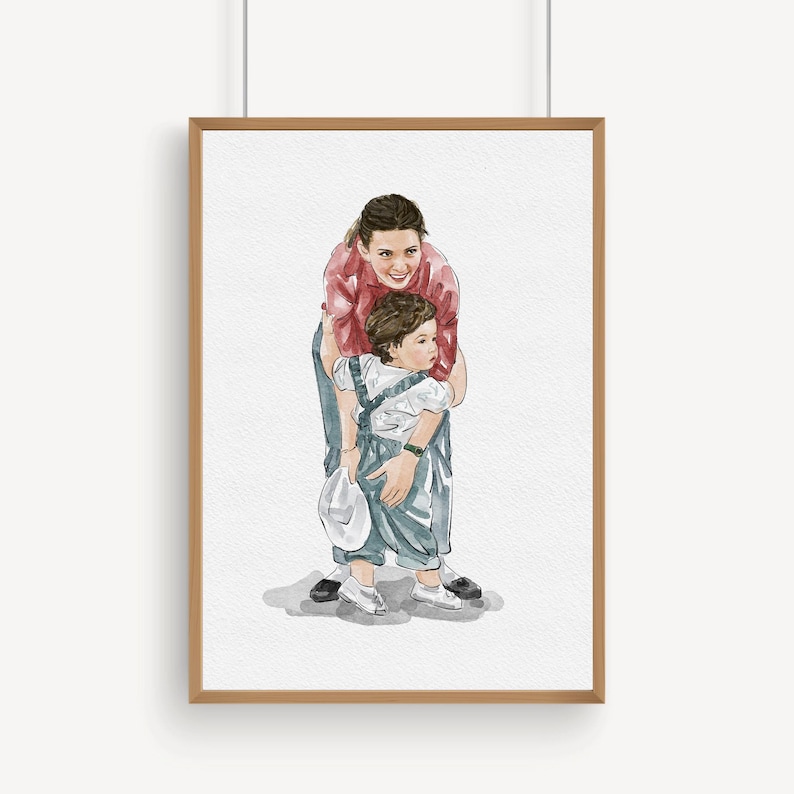 K&ouml;nnte beinhalten: Aquarellportr&auml;t einer Mutter und eines Kindes in einem Holzrahmen. Die Mutter tr&auml;gt ein rotes Hemd und Jeans, umarmt das Kind in blauen Latzhosen und einem wei&szlig;en Hemd. Das Kind h&auml;lt einen wei&szlig;en Hut. Das Kunstwerk befindet sich auf wei&szlig;em Hintergrund.