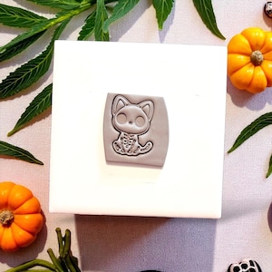 Halloween cat skeleton cutter and clay impression on white block with leaves and pumpkins