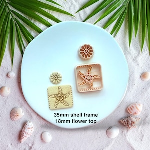 May include: A light pink, beach-themed cookie cutter set. The set includes a square starfish frame, a round flower, and a starfish cookie. The starfish frame measures 35mm, and the flower top is 18mm. The set is displayed on a white plate with seashells and palm leaves.
