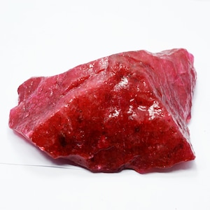 以下が含まれることがあります： 大きな、粗い、赤い宝石。宝石は滑らかで磨かれた表面を持ち、深く豊かな赤色をしています。