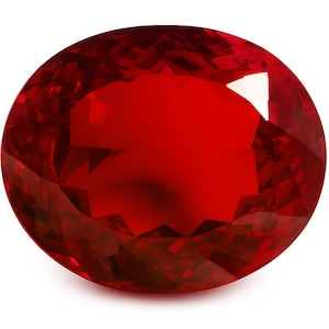 May include: A faceted, oval-shaped, deep red gemstone. The gem has a brilliant, polished surface with multiple facets that reflect light. The color is a rich, saturated red, with a slight variation in tone across the surface. The gemstone is set against a white background.