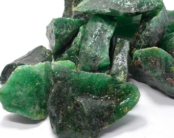 May include: A pile of rough, green gemstone chips. The chips are various sizes and shapes, with a translucent, slightly cloudy appearance.