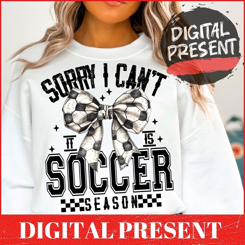 May include: White sweatshirt with black text that reads "Sorry I can't it is soccer season" with a black and white soccer ball bow.
