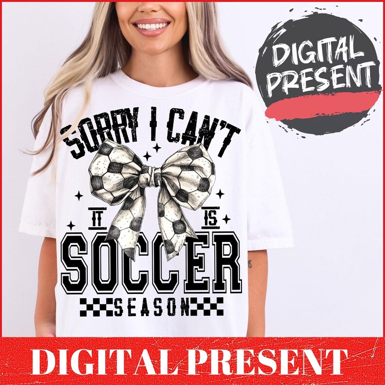 May include: White t-shirt with black text that reads "Sorry I Can't It Is Soccer Season" with a black and white soccer ball bow.