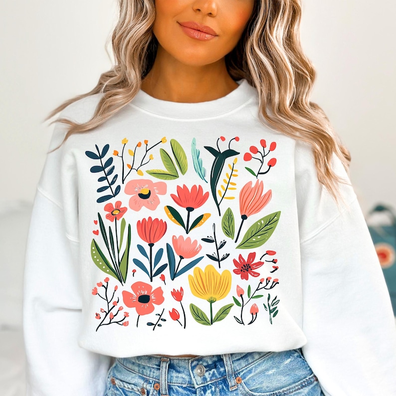 May include: White sweatshirt with a colourful floral print featuring pink, red, yellow, and green flowers and leaves.