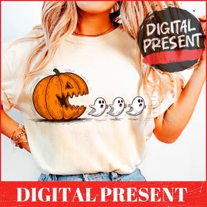 Puede incluir: Camiseta color crema con un gráfico de Halloween. El diseño incluye una calabaza naranja con boca tallada y tres fantasmas blancos. El texto "DIGITAL PRESENT" se muestra en una pancarta roja.