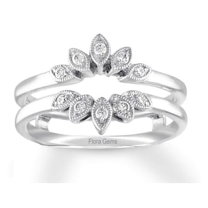 Peut inclure: Une bague en argent avec un motif délicat de diamants de forme marquise sertis dans un motif de feuilles. La bague est une double bande et porte l'inscription "Flora Gems" à l'intérieur.