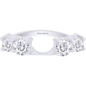 May include: A silver ring with a split shank and four round cubic zirconia stones. The ring is engraved with the words "Flora Gems".