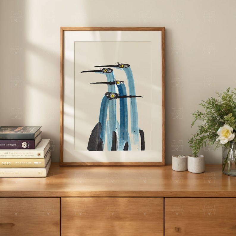 May include: A framed watercolor painting of four blue birds with yellow eyes, their necks elongated and their beaks pointed. The birds are arranged in a vertical line, with the top bird's head tilted to the side. The background is a light gray.