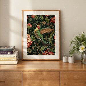 May include: A framed print of a hummingbird with green and yellow feathers flying over a dark green background with red flowers.