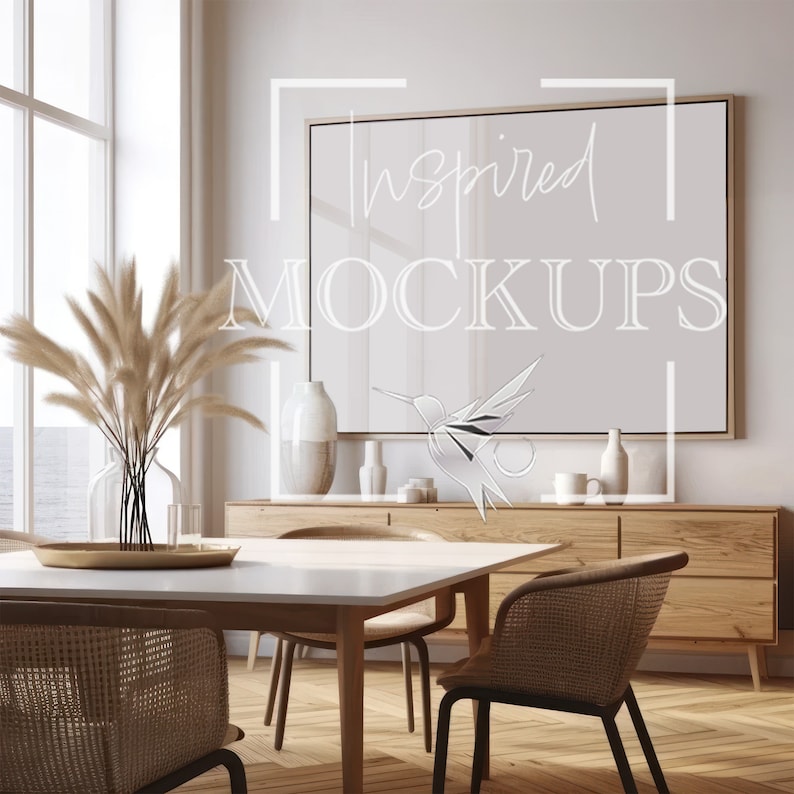Puede incluir: Una mesa de comedor blanca con un marco de madera clara y cuatro sillas. La mesa est&aacute; puesta con una bandeja dorada y un jarr&oacute;n de hierba de la pampa seca. Una gran impresi&oacute;n enmarcada con el texto "Inspired Mockups" cuelga en la pared detr&aacute;s de la mesa.