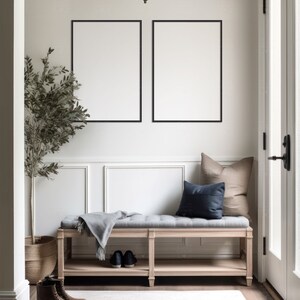 Pode incluir: Um banco de madeira clara com um assento cinza e uma manta. O banco tem uma prateleira embaixo e &eacute; colocado em frente a uma parede branca com duas fotos emolduradas em preto. Uma planta em vaso est&aacute; &agrave; esquerda do banco e um tapete est&aacute; no ch&atilde;o.