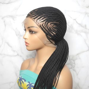 May include: A black braided lace front wig featuring intricate cornrow patterns that sweep across the scalp in a curved design, gathered into a low ponytail. The wig includes a sheer lace base at the hairline, showcasing a natural-looking scalp area.
