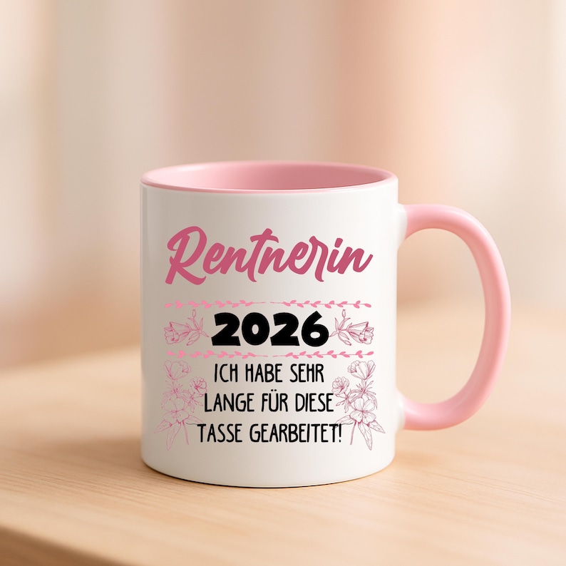 May include: A white ceramic mug with a pink interior and handle. The mug features the word "Rentnerin" in pink script, the number "2026" in black, and the German text "ICH HABE SEHR LANGE F&Uuml;R DIESE TASSE GEARBEITET!" in black.